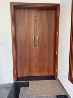 two wooden doors in front of a white wall