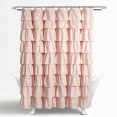 a pink shower curtain with tiered ruffles on the top and bottom, in front of a white bathtub