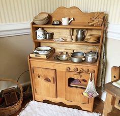 an old fashioned wooden stove with pots and pans on it's top shelf