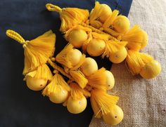 yellow flowers are arranged on a blue cloth with beads and tassels hanging from them