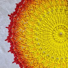 a crocheted doily with yellow and red colors