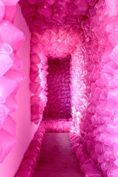 the inside of a pink room with lots of plastic bags on the walls and floor