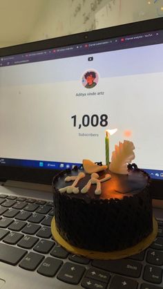 a birthday cake sitting on top of a laptop computer