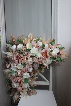 a bouquet of flowers sitting on top of a white table in front of a door