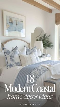 a bedroom with white and blue bedding, pillows and blankets on top of the bed