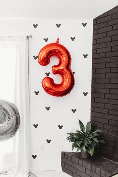 a balloon shaped like the number three hanging on a wall