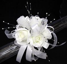 a bouquet of white flowers and pearls on a clear tube with beaded stems in the center