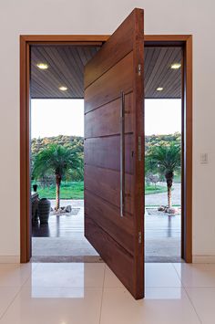 an open door leading to a patio with palm trees