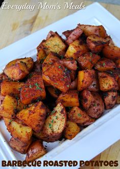 a white plate topped with cooked potatoes on top of a wooden table