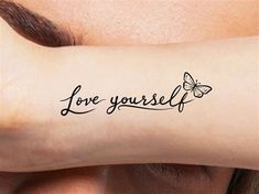 a woman's arm with the words love yourself on it and a butterfly tattoo