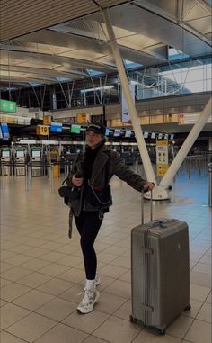 a woman is standing with her luggage at the airport