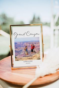 an image of a grand canyon on a wooden table with white feathers in the foreground