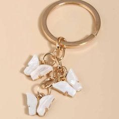 a keychain with some white rocks hanging from it's side on a beige surface