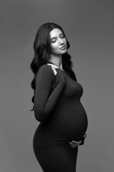 a pregnant woman poses for a black and white photo