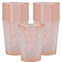 four pink glass vases sitting next to each other on a white background with gold speckles