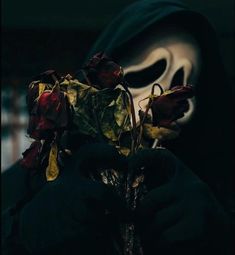 a person wearing a mask with flowers in front of them and a ghost behind it