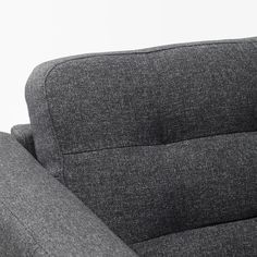 the back end of a gray couch against a white wall