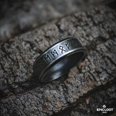 a ring with the word max engraved on it sitting on top of a tree trunk