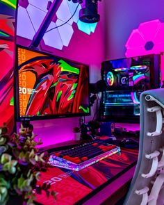 a desk with a computer monitor, keyboard and mouse in front of colorful wallpaper