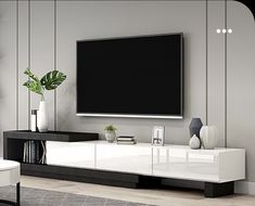 a white and black entertainment center with a large television on it's sideboard