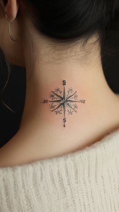 A small black compass tattoo on the side of a woman's neck, elegantly inked with fine lines. The tattoo should be detailed yet simple, showcasing intricate details without any inscriptions.