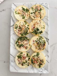 mini pizzas with cheese and herbs on a marble platter