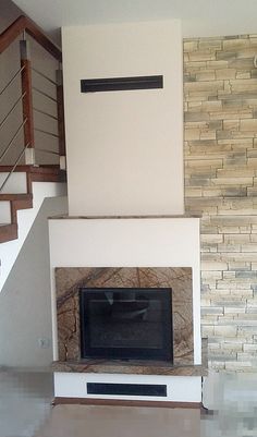 an empty living room with a fireplace and stairs