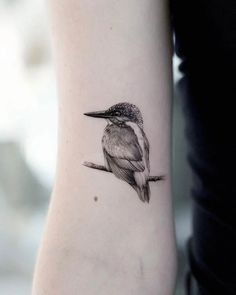 a small bird tattoo on the arm