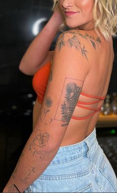 a woman with tattoos on her arm and chest