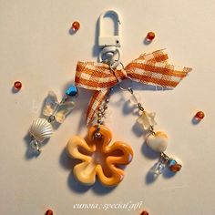 an orange and white keychain with charms attached to it's side on a table