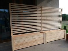 two wooden planters sitting next to each other on top of a cement floor near a building