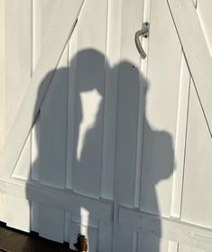 the shadow of a person standing in front of a white door