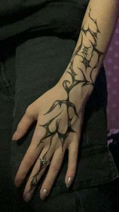 a woman's hand with tattoos on it