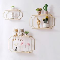 three wall mounted shelves with plants and stuffed animals on them, hanging from the wall