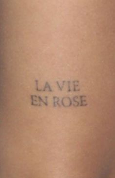 a woman's leg with the words la vie en rose tattooed on it