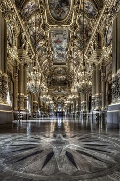 an ornately decorated hall with chandeliers and paintings on the ceiling is shown