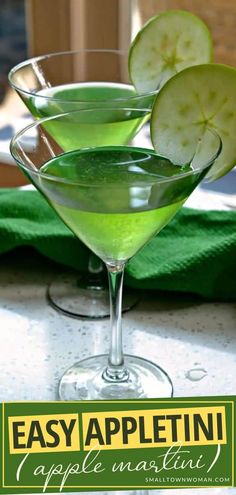 two glasses filled with green liquid sitting on top of a table