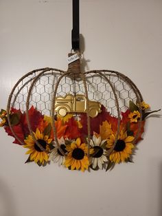 a decorative pumpkin with sunflowers, leaves and a truck on it's side