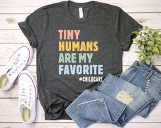 Childcare Tiny Humans Are My Favorite Shirt - Unisex T Shirt, Women Racerback Tank, Long Sleeve T-Shirt Tees Tshirt Sweatshirt Sweater Hoodie Gift For Men Women Boys Girls DAYCARE Teacher Shirt Daycare Teacher Gift Cute Daycare Custom Daycare Teacher Gift Tee Mom Everyday I'm T-shirt Custom Daycare Life Shirt Tiny Humans Are My Favorite #Childcare T-Shirt Well, let's say goodbye to all this boring apparel... The GodBlessThisDesign team creates custom clothes with great designs to suit all tastes Architect Student, The Wombats, Dope Shirt, Reading Shirts, Book Tshirts, Dog Mom Shirt, Dog Lover Shirt, Book Shirts, Nursing Shirts