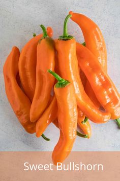 several orange hot peppers with the words sweet bullhorn on it's front and side