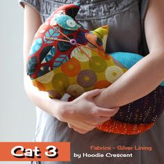 a woman holding a colorful stuffed animal in her hands with the caption cat 3 fabric silver lining by hoida crescent