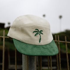 A two-tone corduroy hat with an embroidered palm tree and the perfect palm green to match. This hat has an adjustable velcro back and been worn on toddlers, big kids, moms, and dads -- it literally looks good on everyone. Size 1: Designed to fit kids aged 9 months to 2 years Size 2: Designed to fit kids aged 3 to 5 years Size 3: Designed to fit kids aged 6 to 10 years Adult: One size fits most Not sure on sizing? Check out our guide. Tips for cleaning your hat can be found here. Cotton Snapback Trucker Hat For Vacation, Casual 5-panel Snapback Hat For Vacation, Green Adjustable 5-panel Dad Hat, Adjustable Green 5-panel Dad Hat, Summer 5-panel Hats, Summer Cotton Snapback Hat, Cotton 5-panel Trucker Hat For Beach, Green 5-panel Baseball Cap For Summer, Green 5-panel Beach Baseball Cap