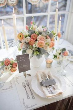 the table is set with silverware, flowers and candles for an elegant wedding reception