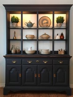 a black china cabinet with dishes on it