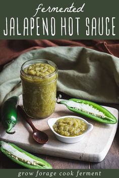 a jar of jalapeno hot sauce on a cutting board with spoons