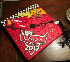 a red graduation cap with cars on it