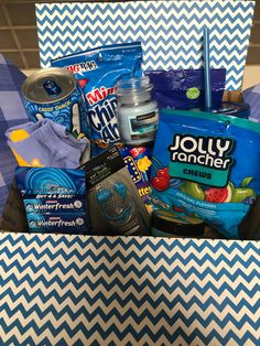 a box filled with food and snacks on top of a blue and white checkered table cloth