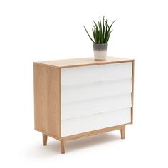 a white and wood dresser with a potted plant sitting on it's top