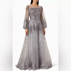 New With Tags Mac Duggal Jewel Encrusted Illusion Long Sleeve A Line Gown Dress Color Platinum Silver Grey Gray Size 20 This Dreamy Gown Is Made With Clusters And Dashes Of Sequins For An Ombr-Like Effect. Cut In A Graceful, A-Line Shape, The Dress Is Styled With An Illusion Round Neck, Bishop Sleeves And A Sparkling Skirt With A Sweep Train Finish. Mac Duggal Sequined Net Overlay; 100% Polyester Lining Partially Lined Bodice; Fully Lined Skirt; Sheer Unlined Sleeves Boat Neckline Long Blouson S Silver Prom Gown For Evening, Silver Sequined Evening Dress For Mother Of The Bride, Gray Embellished Evening Dress For Gala, Embellished Gray Evening Dress For Gala, Luxury Silver Gown For Gala, Silver Sequined Mother Of The Bride Dress For Evening, Silver Embellished Evening Dress For Prom, Luxury Silver Evening Dress For Gala, Silver Sparkling Evening Dress For Gala