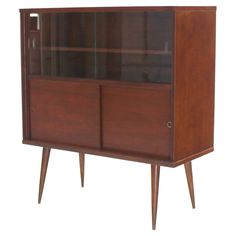 a wooden cabinet with glass doors and legs